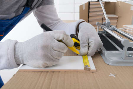 close-up of the master who makes tile markings for further cutting and laying on the wallの写真素材