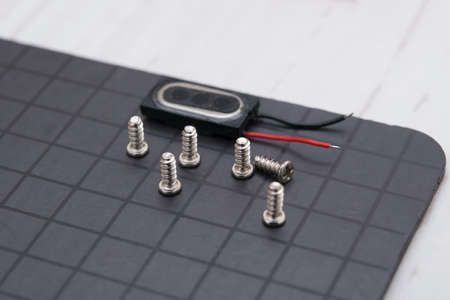 on the magnetic mat there are small parts after disassembling the smartphone, screwsの写真素材