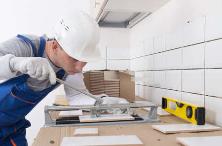 the master of laying ceramics, cuts and breaks the size of the tile, there is a place on the right for the inscriptionの写真素材