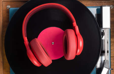 red headphones on old musical vinyl record, close-upの写真素材