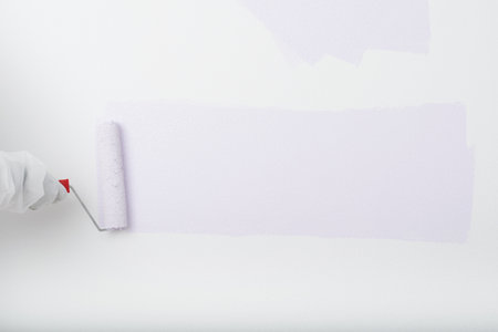purple paint roller paints a strip on the white wall for your letteringの写真素材