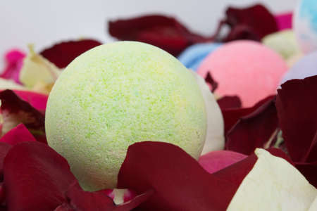 a ball of colored sea salt, surrounded by rose petals, for taking a bath, close-upの写真素材