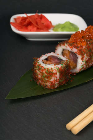 roll with red caviar and fish near ginger and wasabi on a dark backgroundの写真素材