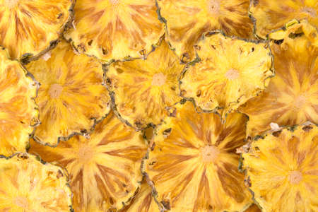 sliced pieces of dried pineapple, close-up, backgroundの写真素材