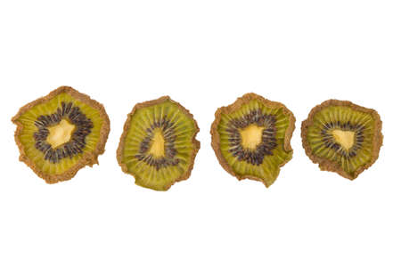 close-up, dried pieces of kiwi fruit of different sizes, laid out in a row, on a white backgroundの写真素材