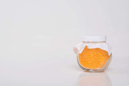 on a white background with a place for the inscription, yellow sea salt for the bathroom, in a glass jarの写真素材