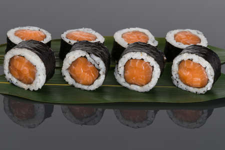 rolls with red salmon lie beautifully on a bamboo leafの写真素材