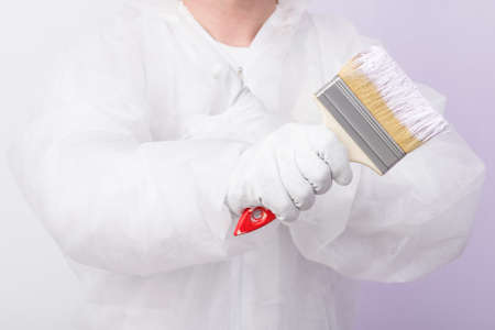 the worker shows a large wide brush holding it in his handの写真素材