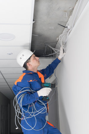 in the suspended ceiling, communications for video surveillance are being installedの写真素材