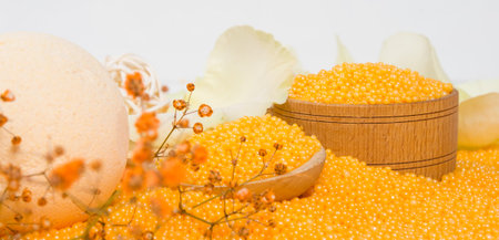 close-up, in wooden containers, orange crumbly bath salt and a white bomb surrounded by rose petalsの写真素材