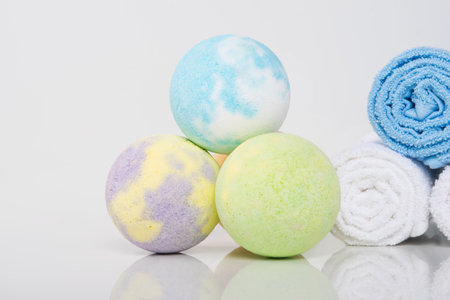 close-up of multicolored bath salts, in the form of bombs and towels rolled up for spa treatmentsの写真素材