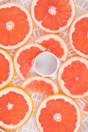 close-up, on a white round grill, grapefruit is cut for further dryingの写真素材