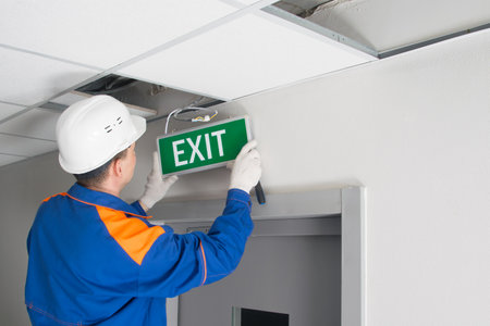 a master in uniform, servicing emergency evacuation exits, repairs the warning systemの写真素材