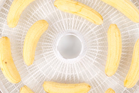 on a white round grate, peeled bananas for further drying, close-upの写真素材