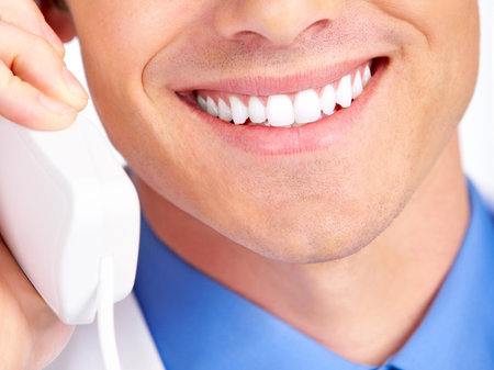 Smiling medical doctor calling by phone. Over white background
の写真素材