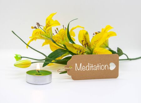 Meditation, a yellow flower and a light isolated on white backgroundの写真素材