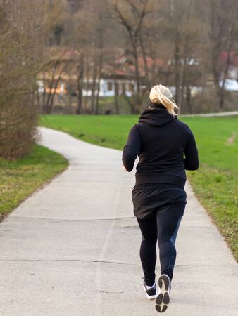 Blonde woman running in a parkの写真素材
