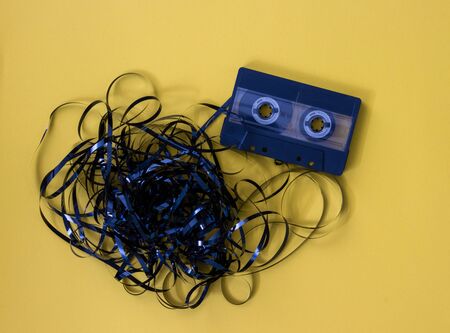 Oldschool black tape isolated on yellow background with magnet stripes taken out.の写真素材