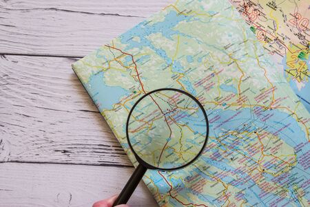 Magnifying glass and ancient map. Copyspace for text. Top view. Flatlay on wooden background.の写真素材