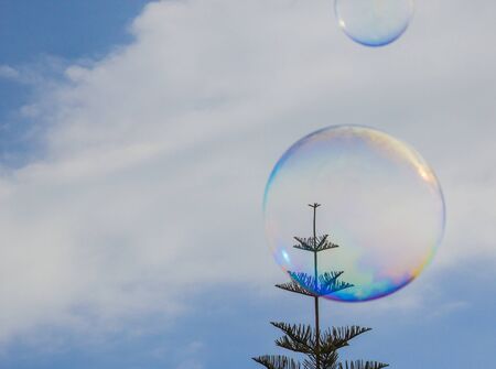 Soap bubble floating in the air as the blue sky. Soap bubble floats calmly against a clear deep blue sky and clouds.の写真素材