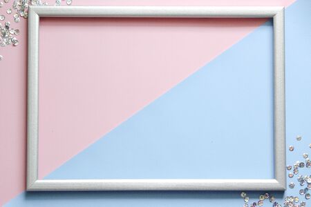 Silver frame with confetti in the corners and space for text on colorful background. Flat lay, top view. Minimal background.の写真素材