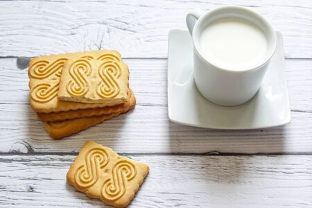 Cup of milk and cookie on a wooden background. Healthy breakfast.の写真素材