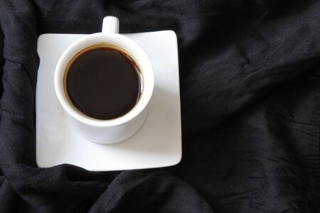 Home cozy composition. Cup of coffe on black background. Cozy background. Flat lay, top view, copy spaceの写真素材