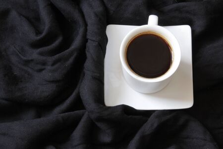 Home cozy composition. Cup of coffe on black background. Cozy background. Flat lay, top view, copy spaceの写真素材