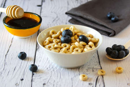 Honey rings with blueberries in a bowl on the table wooden background. Copy space. Top view. Flat lay. Horizontal orientation.の写真素材