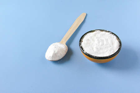 Collagen powder on blue background. Extra protein intake. Natural beauty and health supplement for...