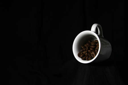 White cup with coffee bean isolated on black background. Food conept. Flat lay, top view.の写真素材