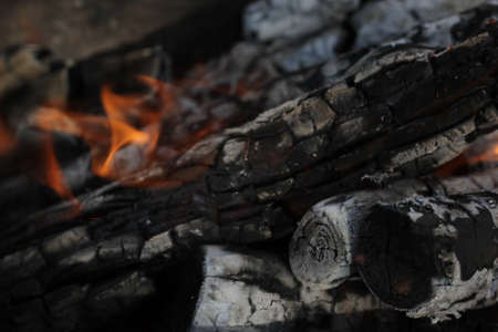Smoldered logs burned in vivid fire close up. Atmospheric background with flame of campfire....