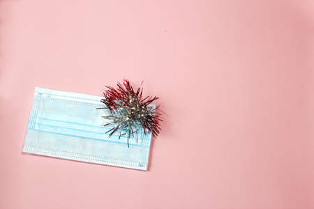 Hygienic face mask on a pink background. Christmas and New Year 2021 decor with space for text....
