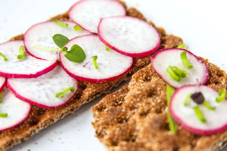 Bread rolls from crisped bread with chopped radishes and herbs. Sandwich with vegetables and basil. Snack close up. High quality photoの写真素材