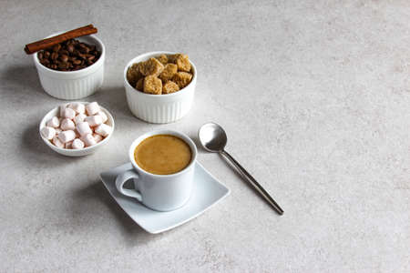 Vanilla coffee with brown sugar and marshmallow. Tasty steam espresso in a cup with coffee beans.
