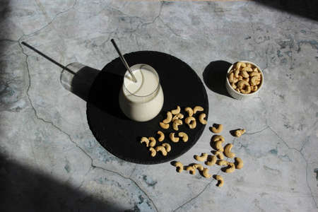 Vegan milk from nuts cashew on the cement table. Vegan or vegetables milk. Top viewの写真素材