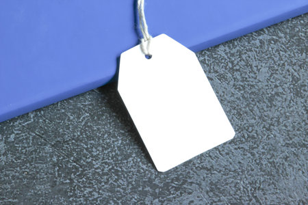 Rectangle white gift tag mockup with white cord, close up on black background