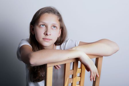 Portrait of a teenage girl sitting on a chairの写真素材