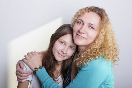 A portrait of mother and duaghter on a light background