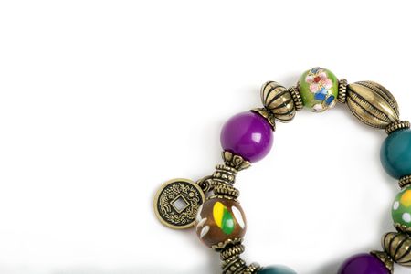 A bracelet with wooden beads and china feng shui coins on a white backgroundの写真素材