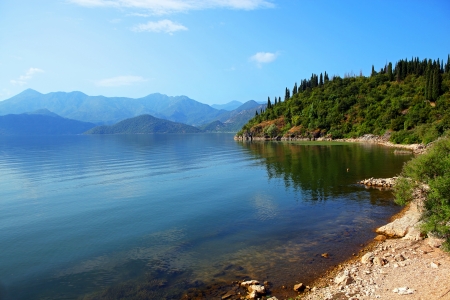 A beautiful landscape with lake, small hills, transparent water and a piece of rocky shore on the front  Skadar lake, Montenegro の写真素材