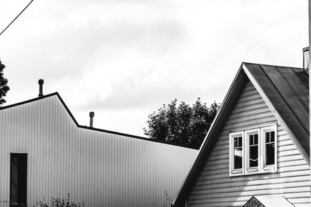 Black and white photo of the roof of a wooden house against the skyの写真素材