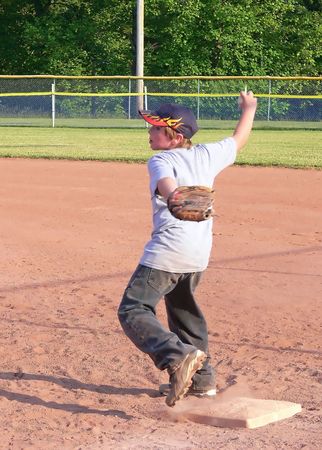 Baseball player  70137	A young baseball player in training on late afternoon with his team.					の写真素材