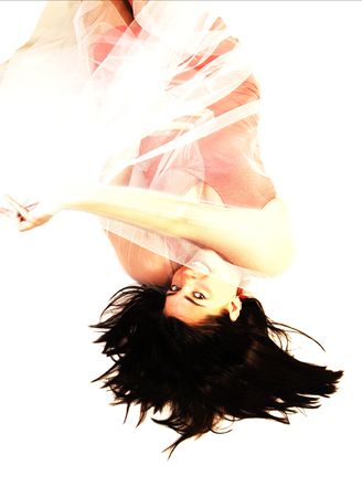 An black haired young woman lying on the floor with in a pink dress and white twill over her body. の写真素材