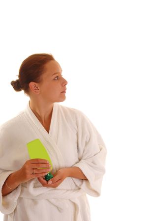 A young woman in an bad robe putting lotion after the shower on her face, for white background.の写真素材