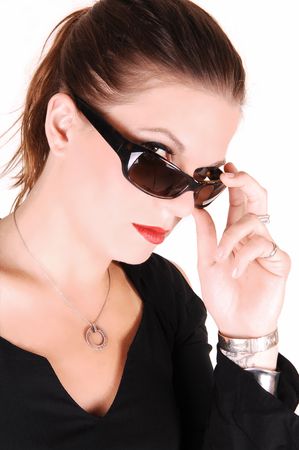 Elegant lady looking over her sunglasses and wearing a black dress for white background in the studio.の写真素材