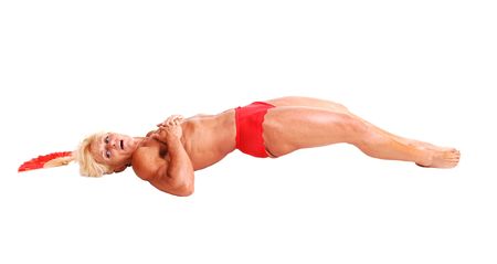 A blond muscular bodybuilding woman lying in the studio shooing her  strong legs and the upper body and arms, topless, over white background.の写真素材