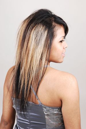 A portrait of a pretty and young Cambodian woman from the back and she turns her head to the side, on light gray background.の写真素材