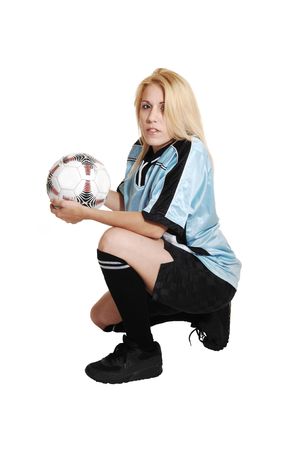 A blond young soccer woman kneeling in the studio in her club uniform
and a soccer ball for white background.
の写真素材
