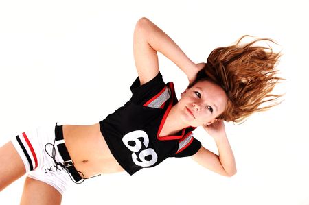 A young teenage soccer girl lying on the floor in her uniform, hands behind her head, for a portrait...